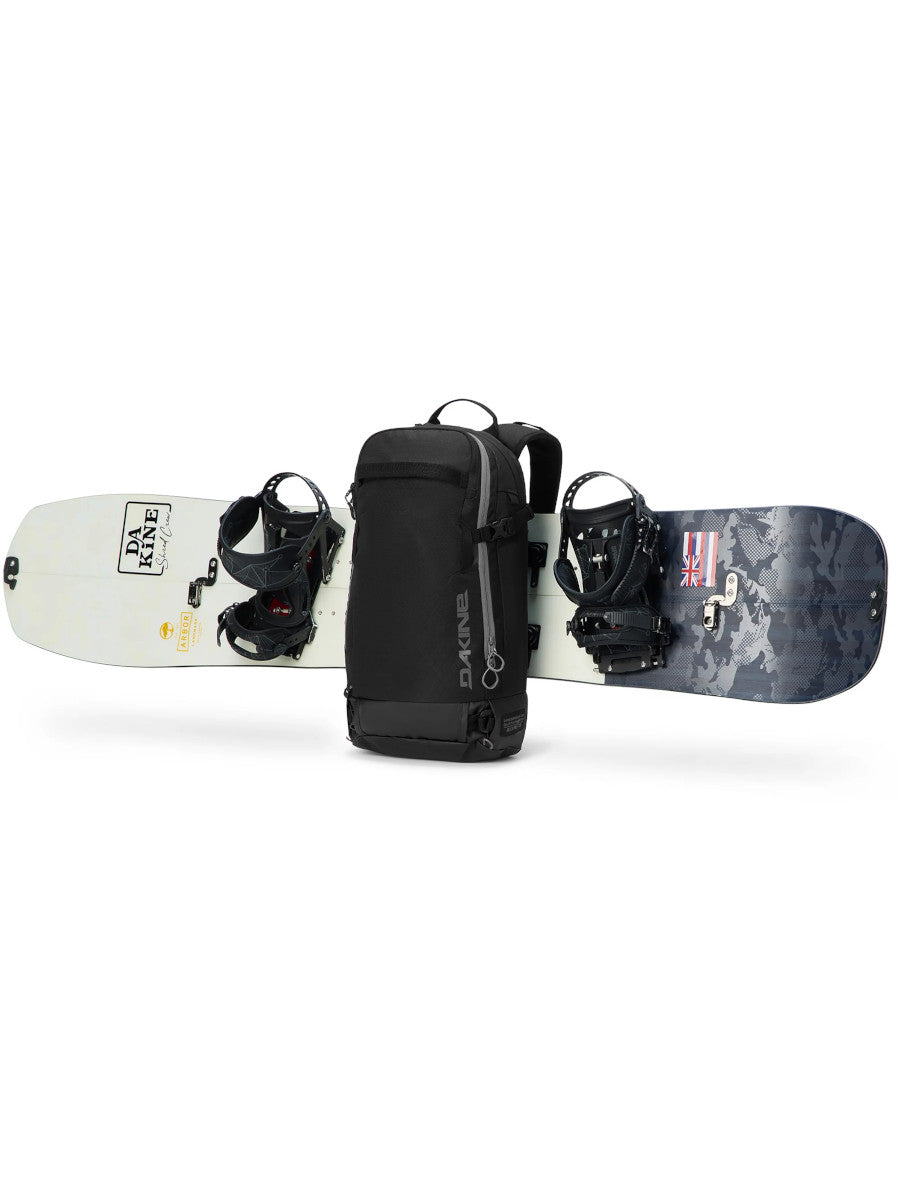 Dakine Heli 2.0 Pro Pack 20L in Black with a snowboard strapped horizontally across the front panel, side view