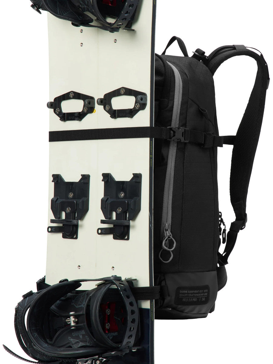 Dakine Heli 2.0 Pro Pack 26L in Black carrying a splitboard vertically on the front panel, side view