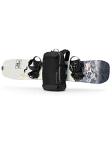 Dakine Heli 2.0 Pro Pack 26L in Black with a snowboard strapped horizontally across the front of the pack