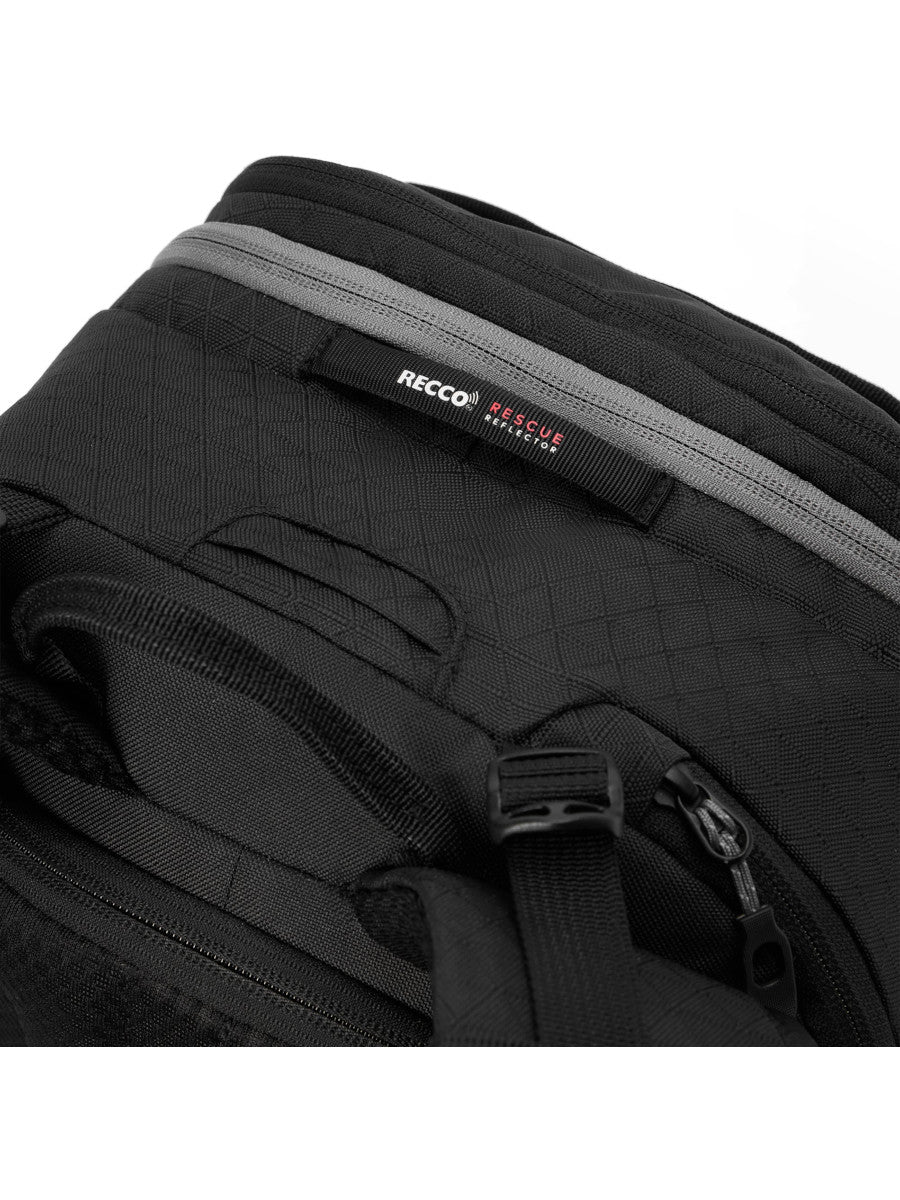Close-up of the Dakine Heli 2.0 Pro Pack 26L in Black showing the RECCO label, grey zip trim and side compression buckle
