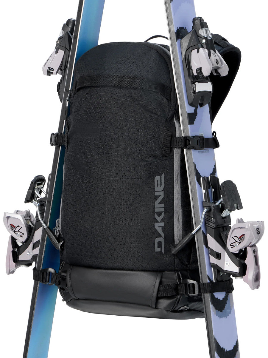 Dakine Heli 2.0 Pro Pack 26L in Black with a pair of skis in A-frame carry on either side, front view