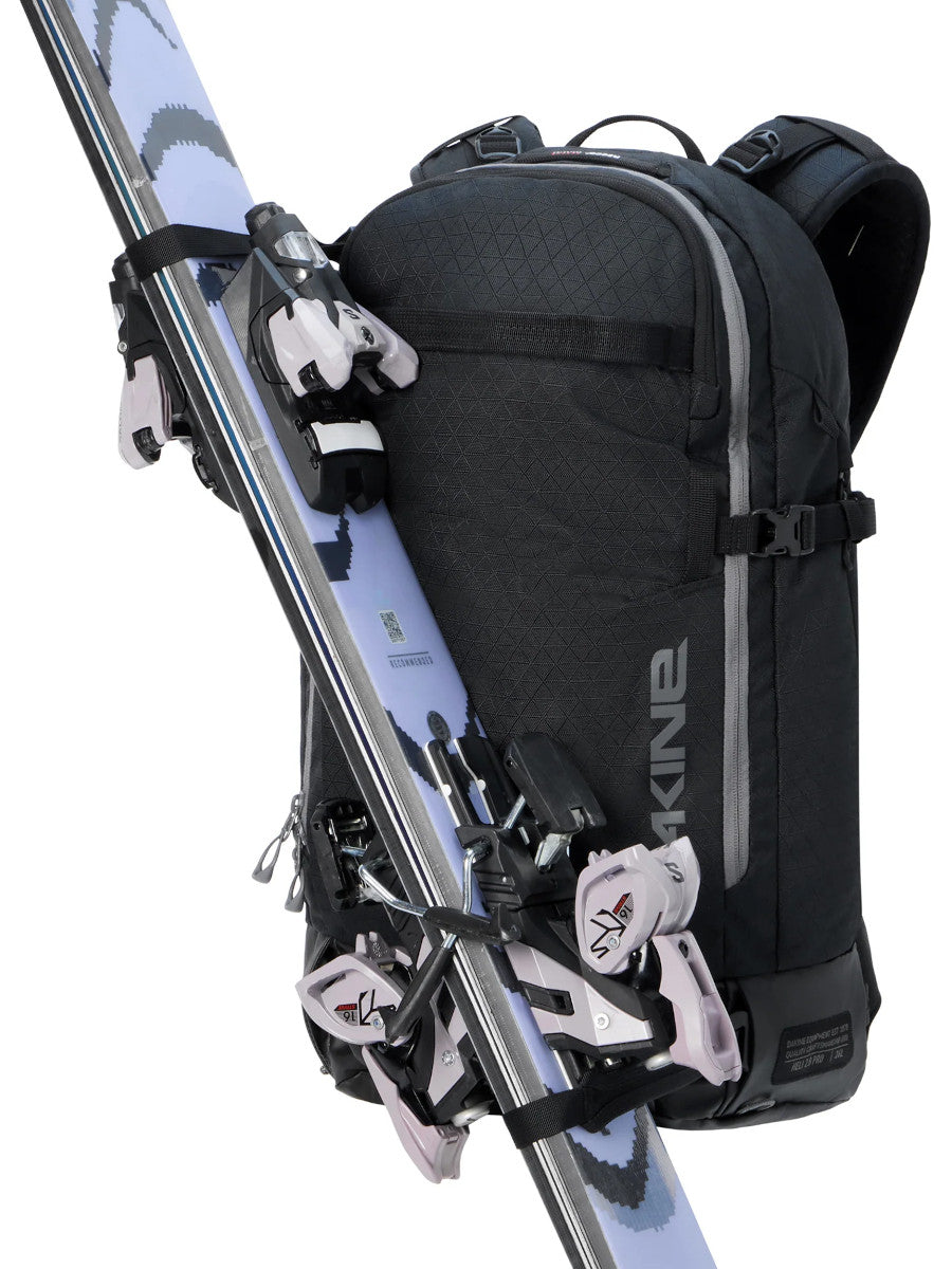 Dakine Heli 2.0 Pro Pack 26L in Black with touring skis strapped diagonally across the front, three-quarter view